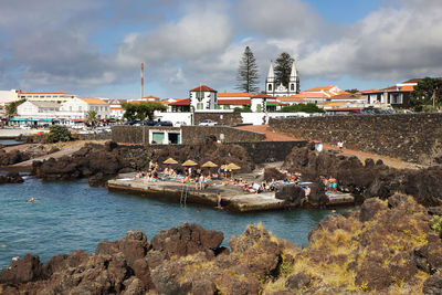 View of town by sea against sky