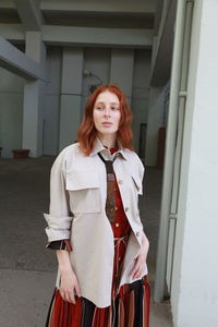 Low angle view of young woman standing against wall