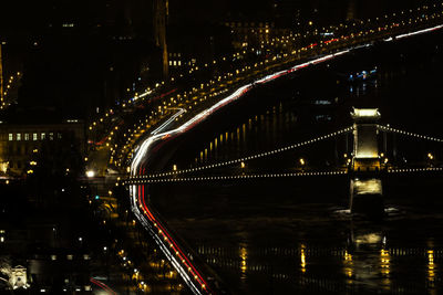 Illuminated bridge over river at night