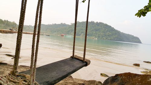 Close-up of swing on beach against clear sky