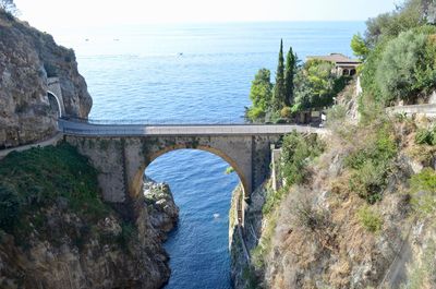 Arch bridge over sea against sky