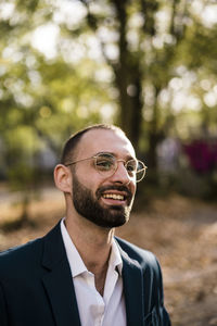 Happy businessman wearing eyeglasses in park