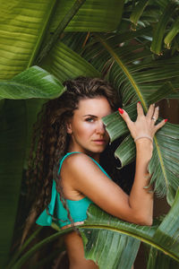 Low angle view of young woman standing amidst plants