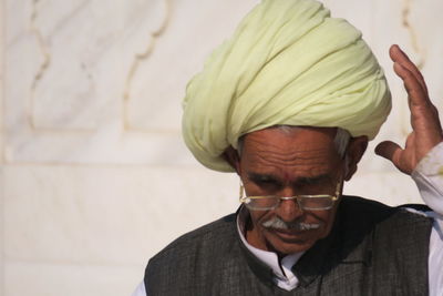 Portrait of man wearing hat against wall