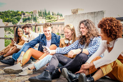 Cheerful friends sitting outdoors