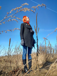 Full length of woman standing on field against sky during winter