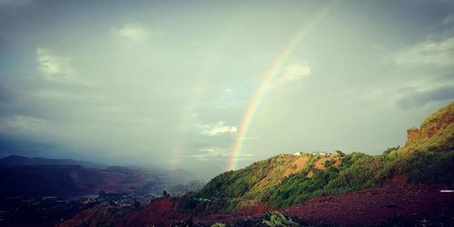 Rainbow over landscape against sky