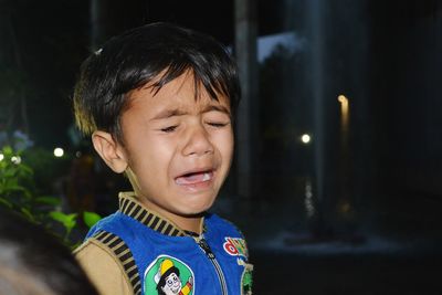 Close-up of boy crying at night