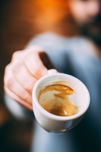 Close-up of hand holding coffee cup