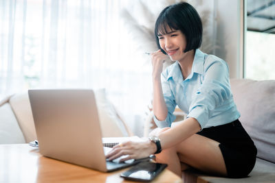 Young woman using laptop at home