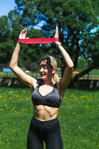 Young caucasian blond-haired woman in sportswear is doing yoga in the park. outdoor workout