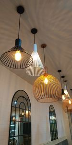 Low angle view of illuminated pendant light hanging in building