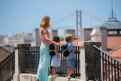 Rear view of woman standing on railing