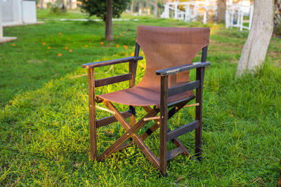 Empty chairs and table on field