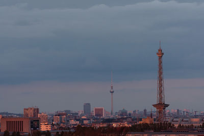 Buildings in city against cloudy sky