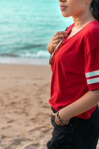 Midsection of woman standing at beach