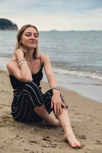 Portrait of young woman sitting at beach
