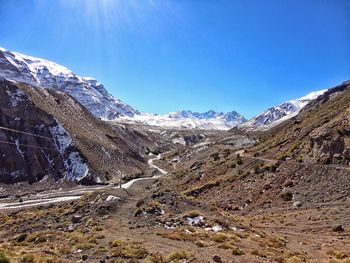 Scenic view of snowcapped mountains against clear blue sky