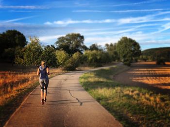 Full length of man running on road against sky