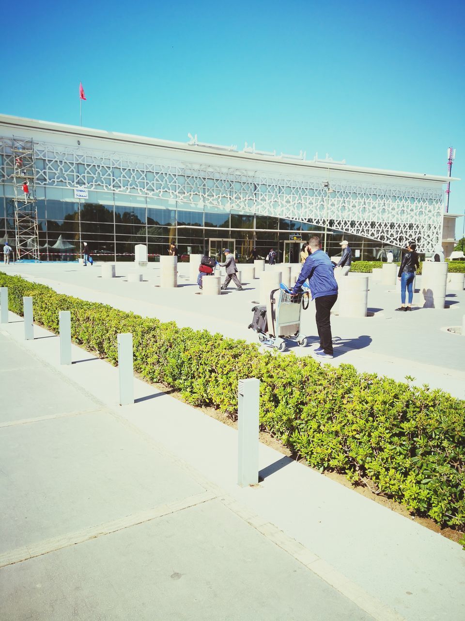 PEOPLE WALKING ON FOOTPATH AGAINST BLUE SKY