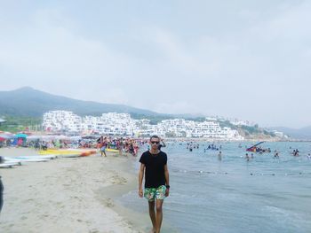 Man standing at beach against sky