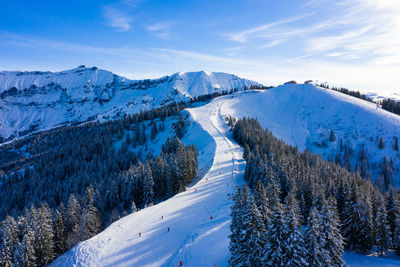 Scenic view of snow covered ski resort against sky