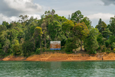 Scenic view of lake by trees against sky