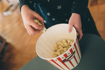 Midsection of woman holding popcorn in bowl