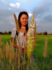 Portrait of smiling young woman standing in farm