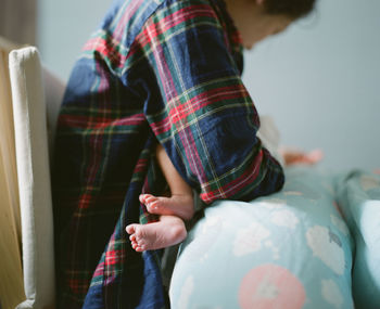 Midsection of woman breastfeeding baby at home