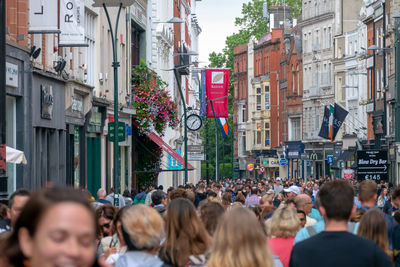 People on street amidst buildings in city