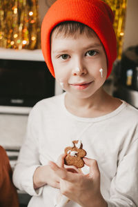 Boy decorate christmas cookies with white icing. children decorate a gingerbread man 