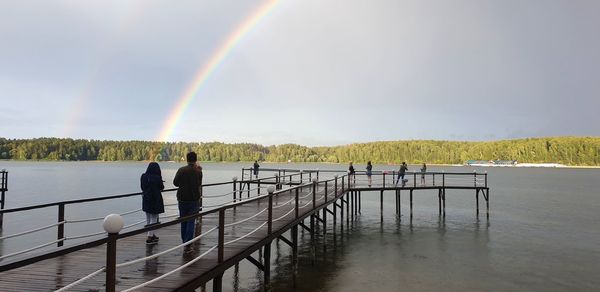 Scenic view of rainbow over river against sky