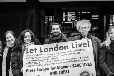 Portrait of people standing against graffiti