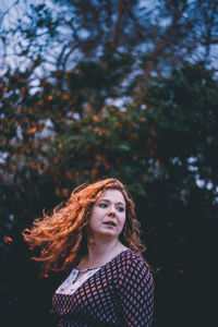 Beautiful young woman against trees