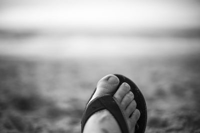 Low section of woman on beach against sky