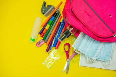 High angle view of multi colored pencils on yellow background