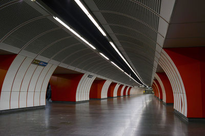 Empty walkway at illuminated subway station