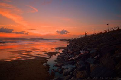 Scenic view of beach against sky during sunset