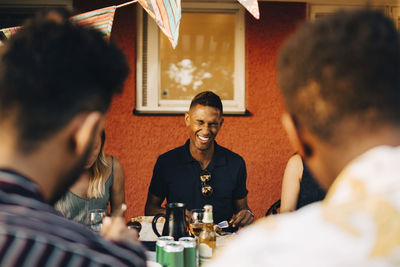 Happy friends enjoying dinner at party in back yard