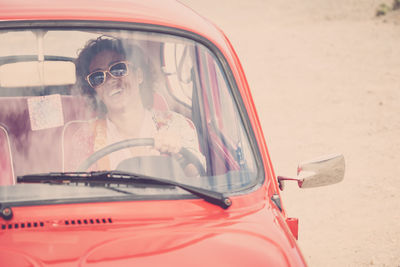 Portrait of a smiling young woman in car