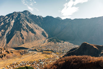 Stepantsminda, kazbegi, goergia. cityscape of big rural town with mountain range of mount kazbak.