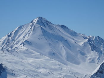 Scenic view of snowcapped mountains against clear blue sky