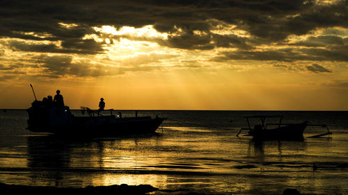 Silhouette boat in sea against sky during sunset