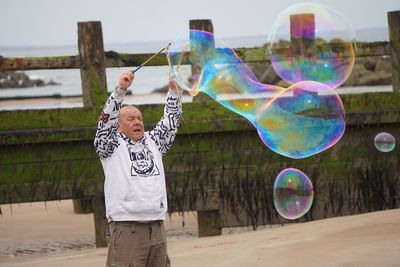 Rear view of woman blowing bubbles