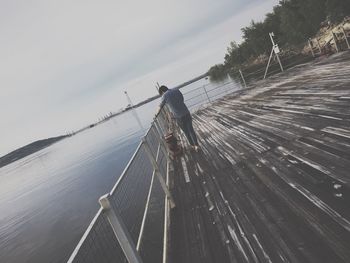 Low angle view of man standing on wood against sky