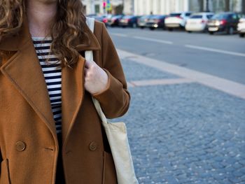 Midsection of woman standing on road