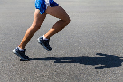 Low section of person running on road