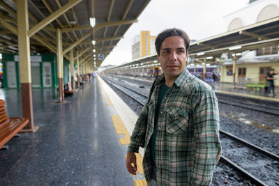 Portrait of man standing on railroad station