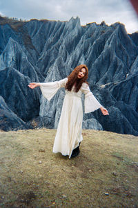 Young woman smiling while standing on mountain